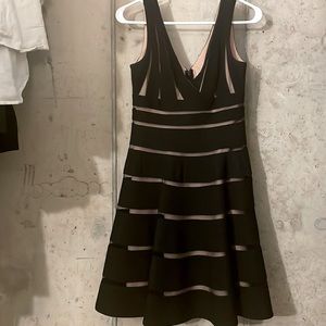 Black JS collections cocktail dress with sheer-over inner nude slip.